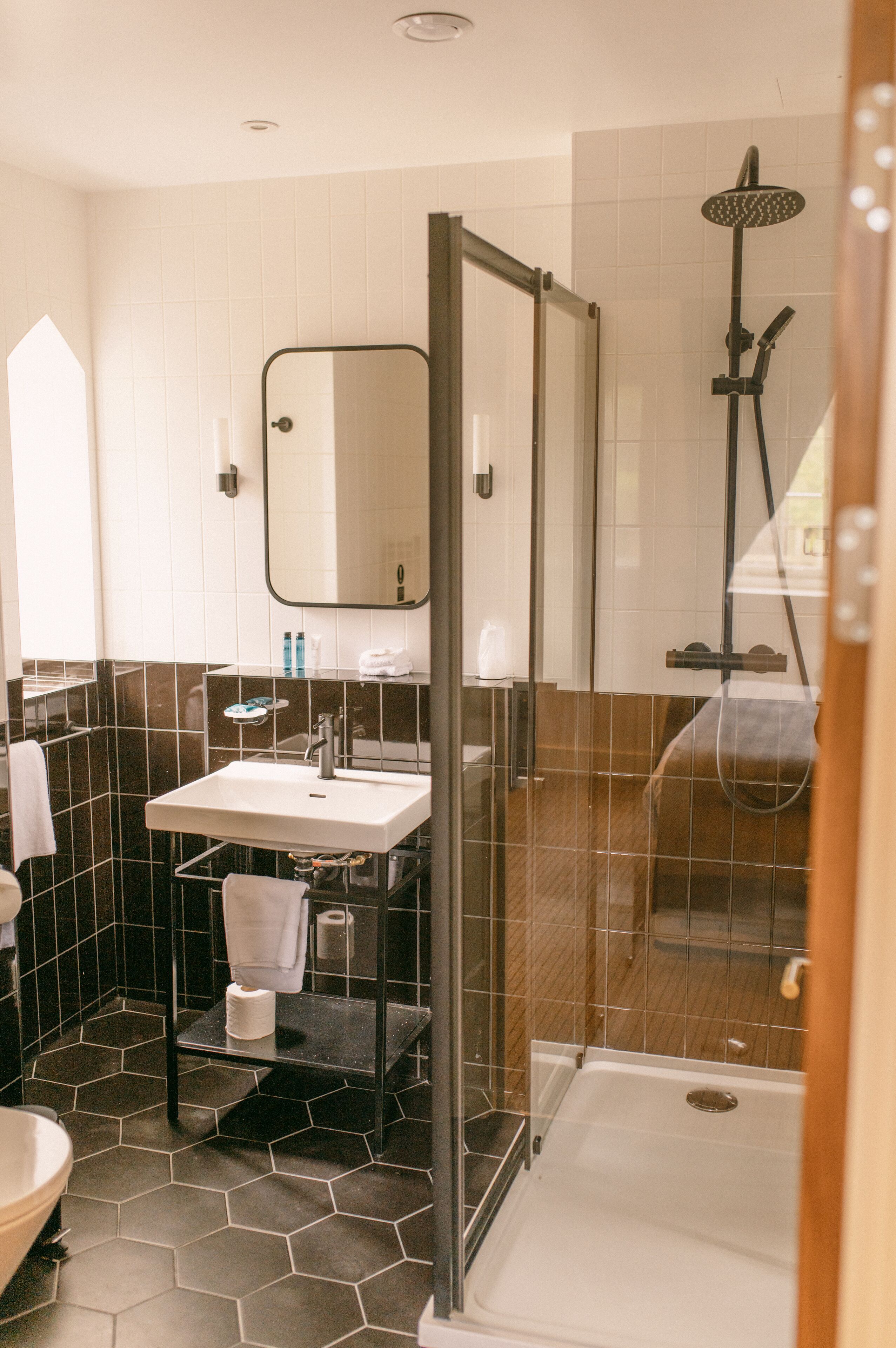 Un baño moderno con ducha envuelta en vidrio, un lavabo y un espejo.