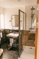 Un baño moderno con ducha envuelta en vidrio, un lavabo y un espejo.