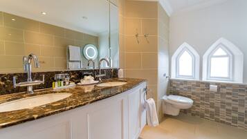 A modern bathroom with two sinks, a large mirror, and a shower.