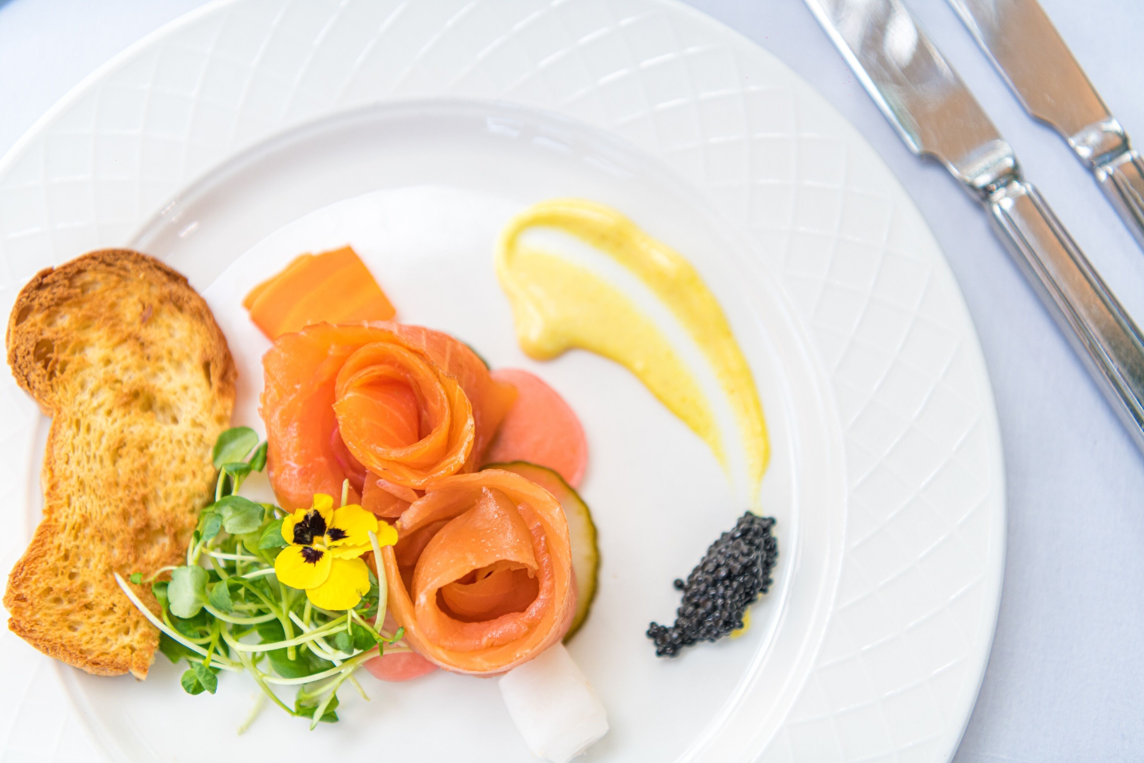 Un plat amb salmó fumat, llimona, caviar i una petita amanida.