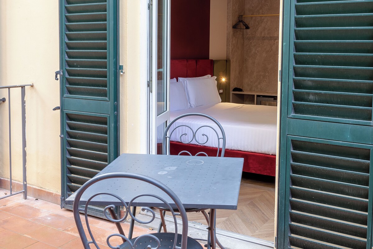 Una stanza con un letto, un tavolo e una sedia.