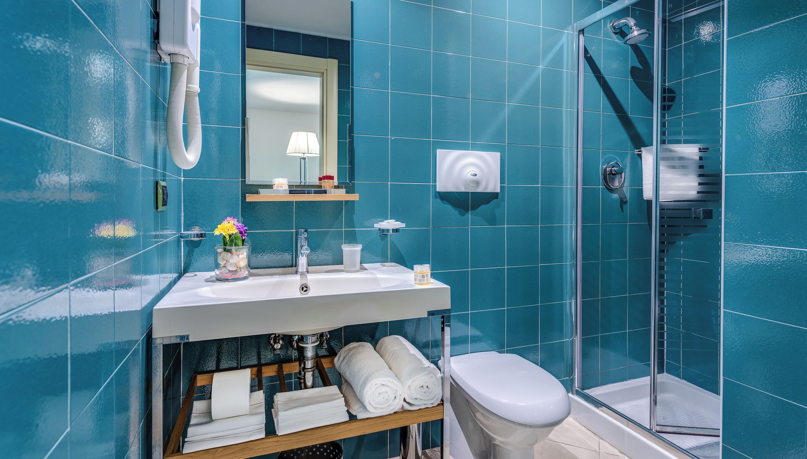 Un bagno con lavandino, specchio e doccia.