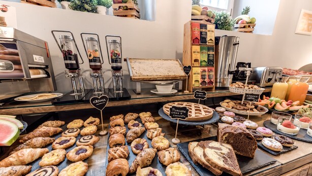 Mostrador de pastelería con diversos dulces y una máquina de café.