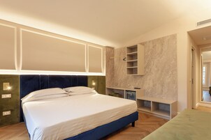 Una camera da letto con un letto grande, scaffali a muro e un comò con specchio.