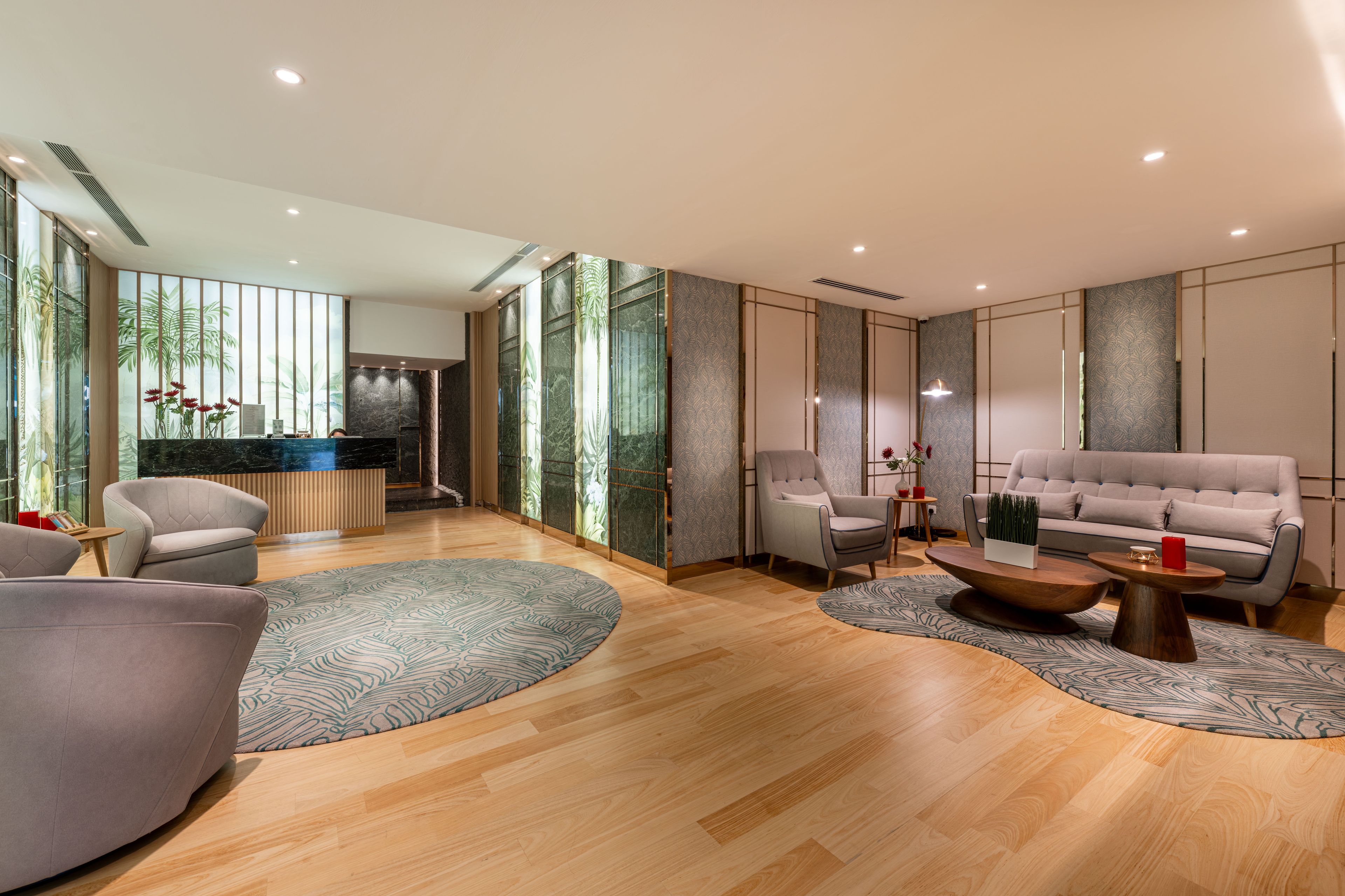 A modern living room with a sofa, armchairs, a coffee table, and a reception desk.