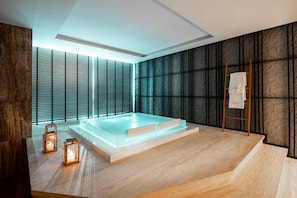 A modern spa room with a large bathtub, wooden floor, and a view through the window blinds. - Pullman Kuala Lumpur City Centre Hotel & Residences (Kuala Lumpur)