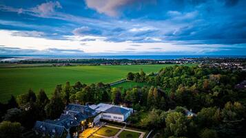 A large estate with multiple buildings, expansive green fields, and a well-maintained garden.