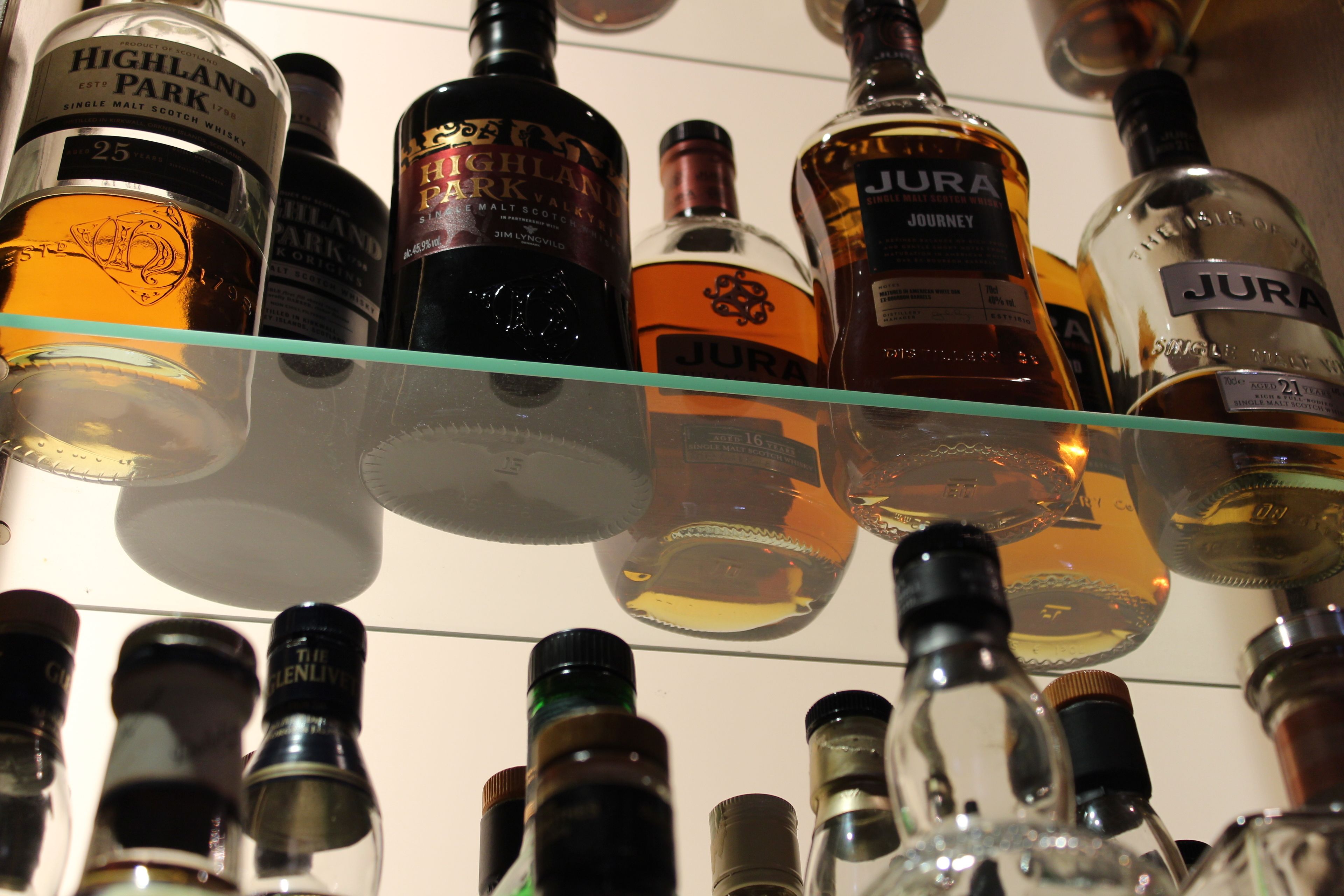 A variety of whisky bottles displayed on a shelf.