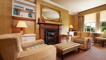 A traditional living room with a fireplace, bookshelves, and comfortable seating.