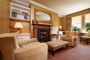 Cozy living room with a fireplace, bookshelf, and comfortable seating.
