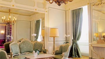 Una habitación lujosa con muebles ornamentales, un candelabro y un espejo grande.