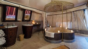 A tented room with a large bathtub, a sink, and a mirror. - Kasbah Agafay Hotel And Spa (Tameslouht)