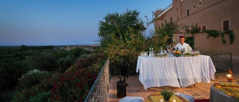 Un coin repas avec une table dressée pour deux personnes, offrant une vue sur un paysage magnifique.