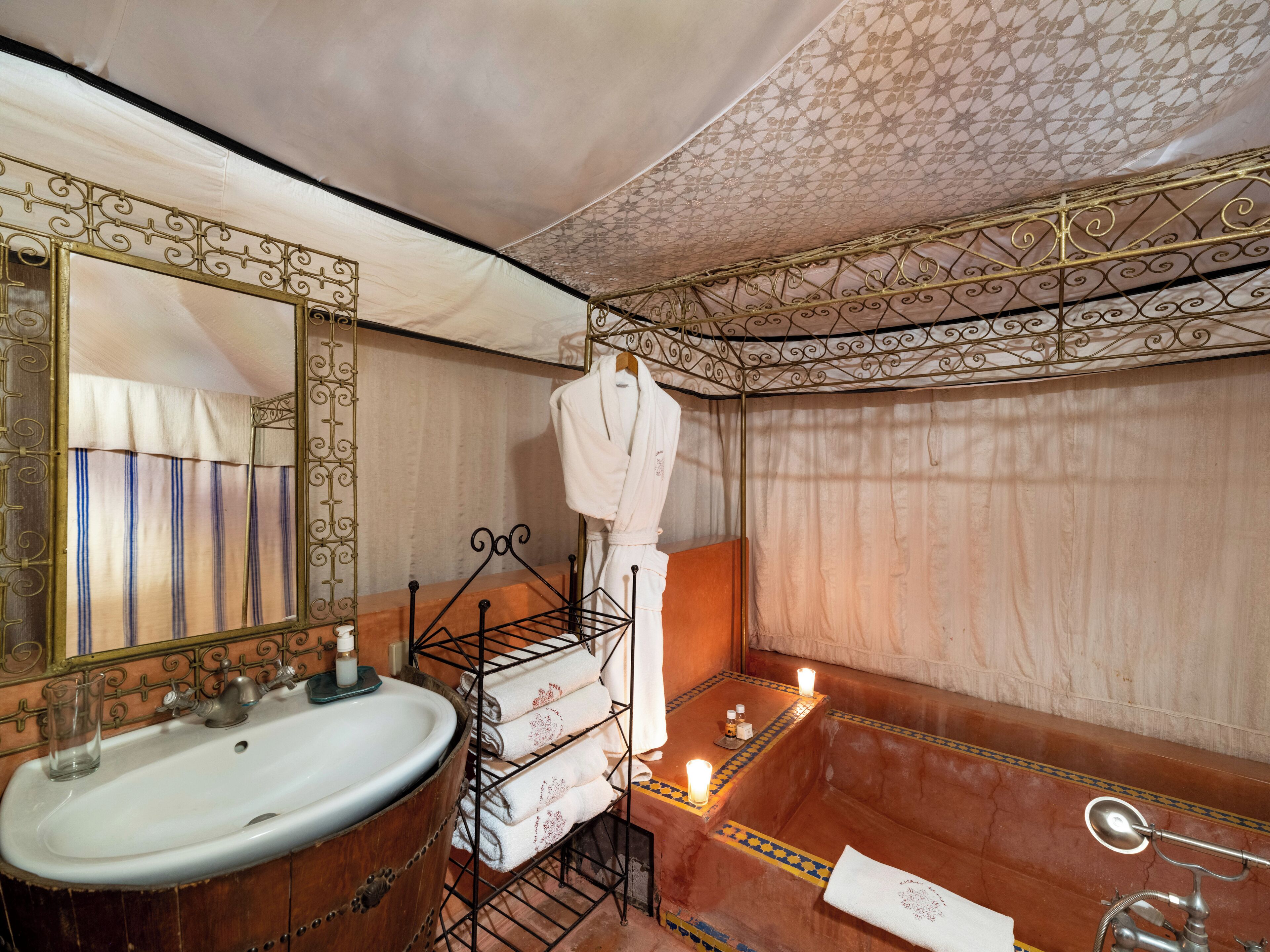 A bathroom with a large mirror, a sink, a bathtub, and a towel rack.