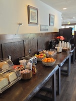 A buffet area with various food items, a coffee bar, and an exit sign.