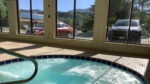 A swimming pool with a clear view of the surrounding landscape through large windows.
