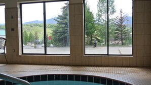 A pool area with a view of a mountain and a parking lot.