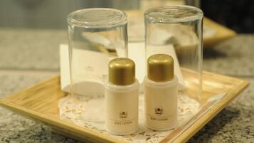 Two bottles of body lotion on a wooden tray with a doily.