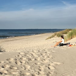 Guests can relax on the beach, surrounded by dunes and the ocean.