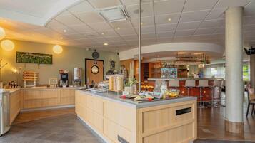 A modern kitchen with a central island, bar area, and seating.