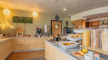 Un espace buffet pour le petit-déjeuner proposant une variété d’aliments et un coin café.