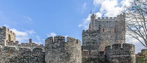 Eine historische Steinburg mit mehreren Türmen und einer Flagge.