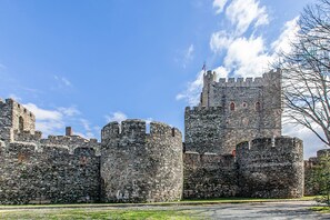 Un château historique en pierre, doté de plusieurs tours et arborant un drapeau.