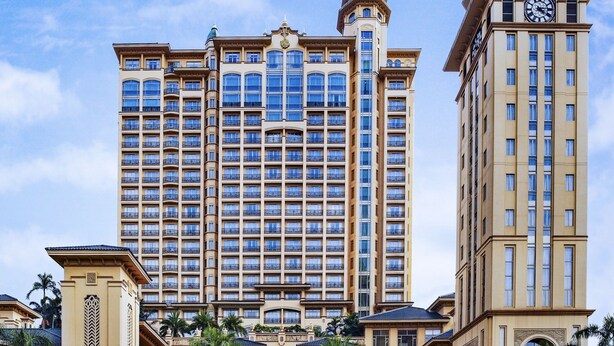 A large, multi-story hotel with a central courtyard, a fountain, and a clock tower. - Chateau Star River Guangzhou (Guangzhou)