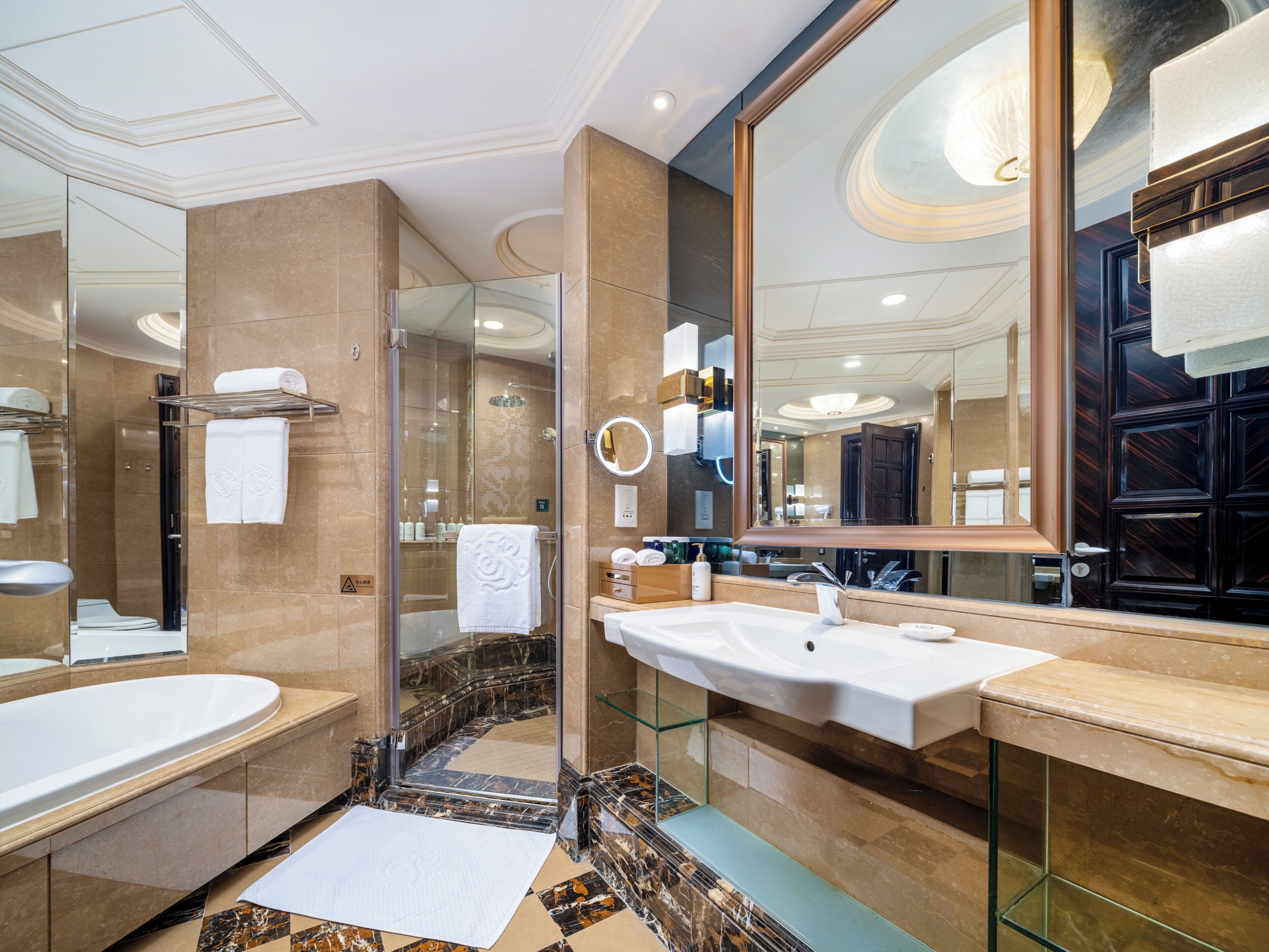 A modern bathroom with a large mirror, two sinks, and a shower.