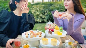 Two people sitting at an outdoor table with a variety of food items and drinks. - Chateau Star River Guangzhou (Guangzhou)