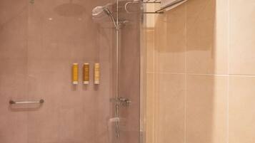 A modern bathroom with a shower, toilet, and towel rack.