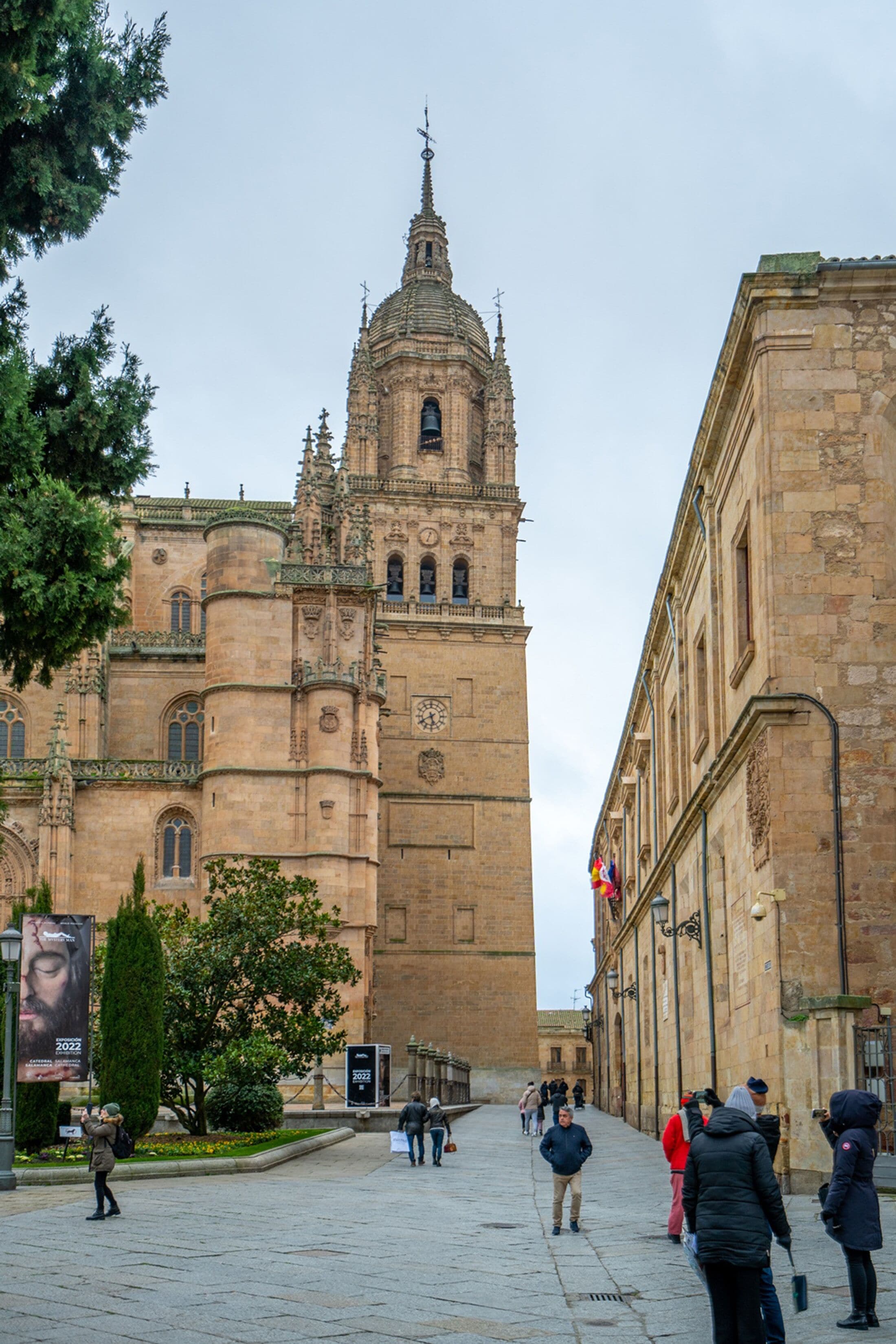 A historic building with a prominent tower and a courtyard.