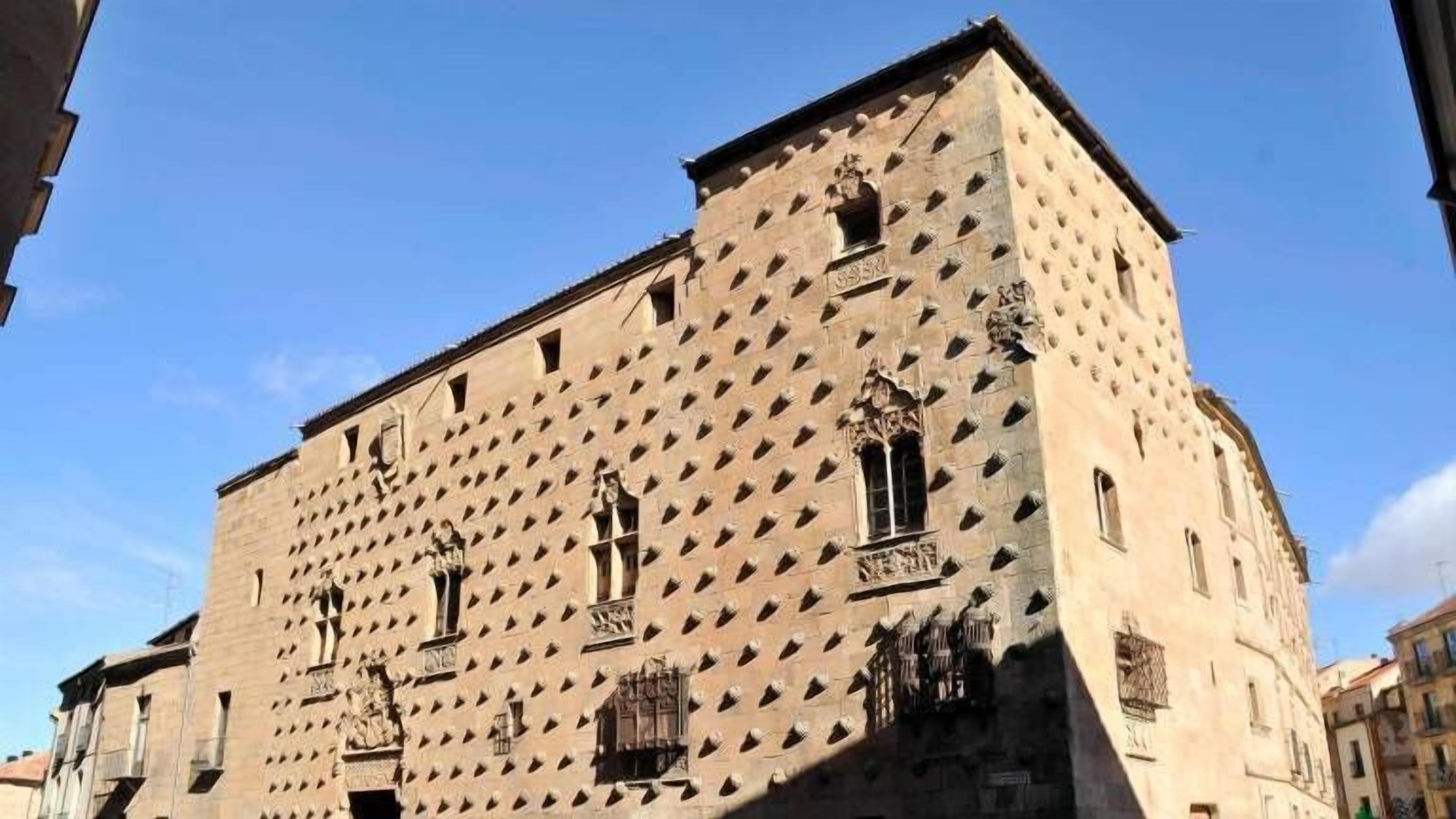 A historic building with a unique geometric facade, multiple windows, and decorative elements.