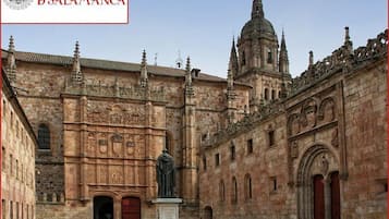 A historic building with intricate stonework, a statue, and a bell tower.