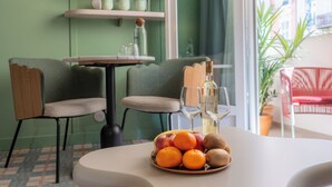 A dining area with a table set for two, featuring a fruit bowl, wine glasses, and a bottle. - Hotel Aparthotel AMMI Nice Lafayette (Nice)