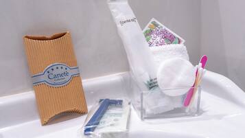 A bathroom sink with a dental kit, a tissue box, and a toothbrush holder.