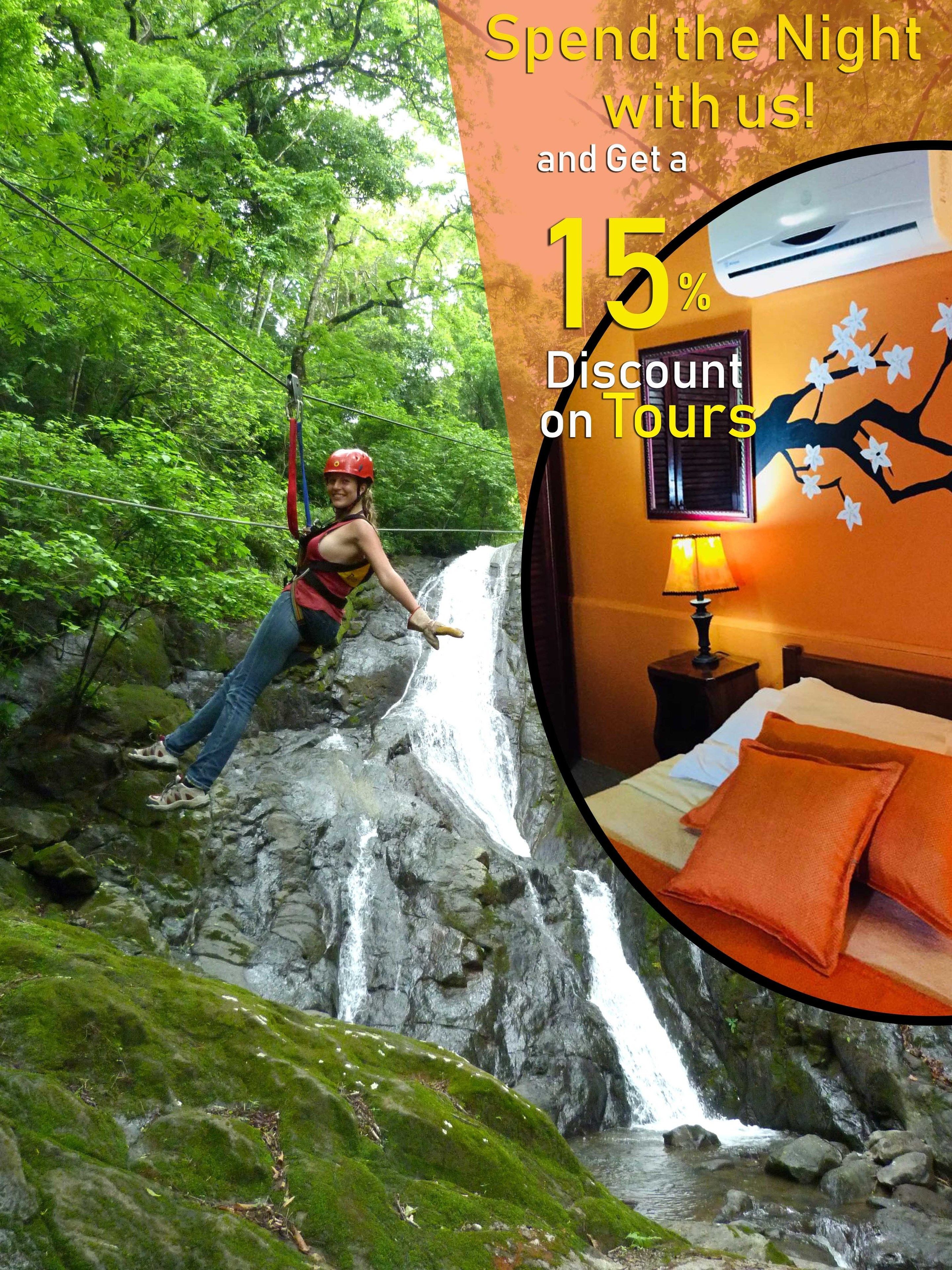 A person rappelling down a waterfall in a forested area.