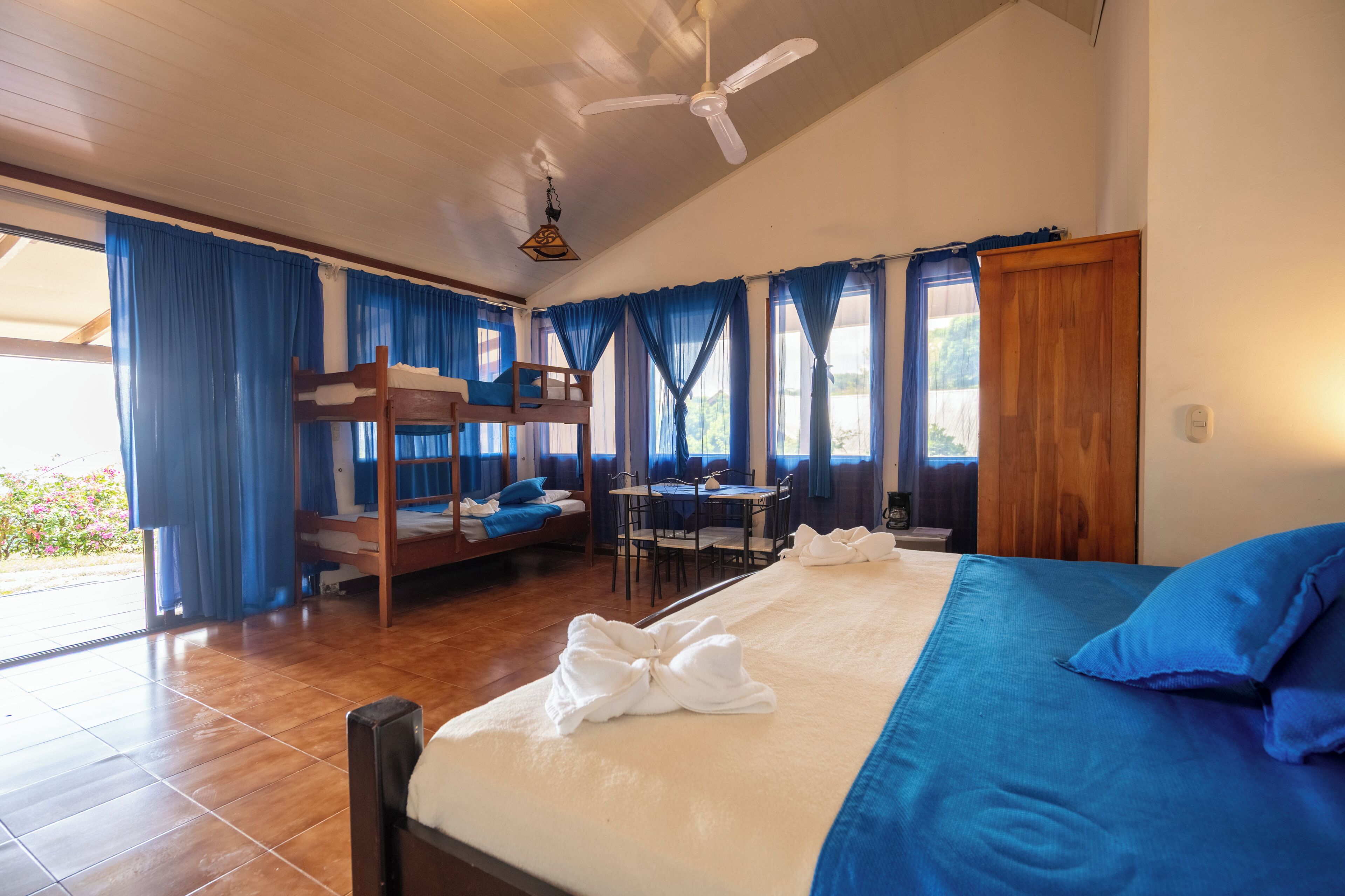 A room with bunk beds, a desk, and a dining table.