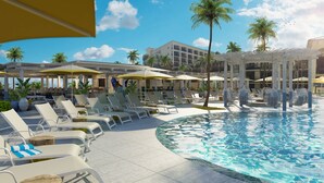 A poolside area with lounge chairs, umbrellas, and a building in the background. - St Pete Shores Hotel (St. Pete Beach)