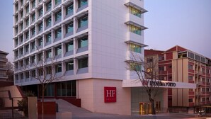 A modern hotel building with a prominent sign, multiple floors, and a clear sky. - HF Ipanema Porto (Porto)