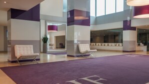 A spacious lobby with a purple carpet and two white armchairs. - HF Ipanema Porto (Porto)