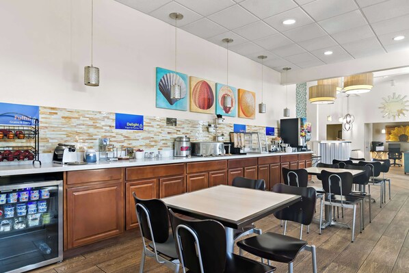 A breakfast area with a counter, seating, and a refrigerator.