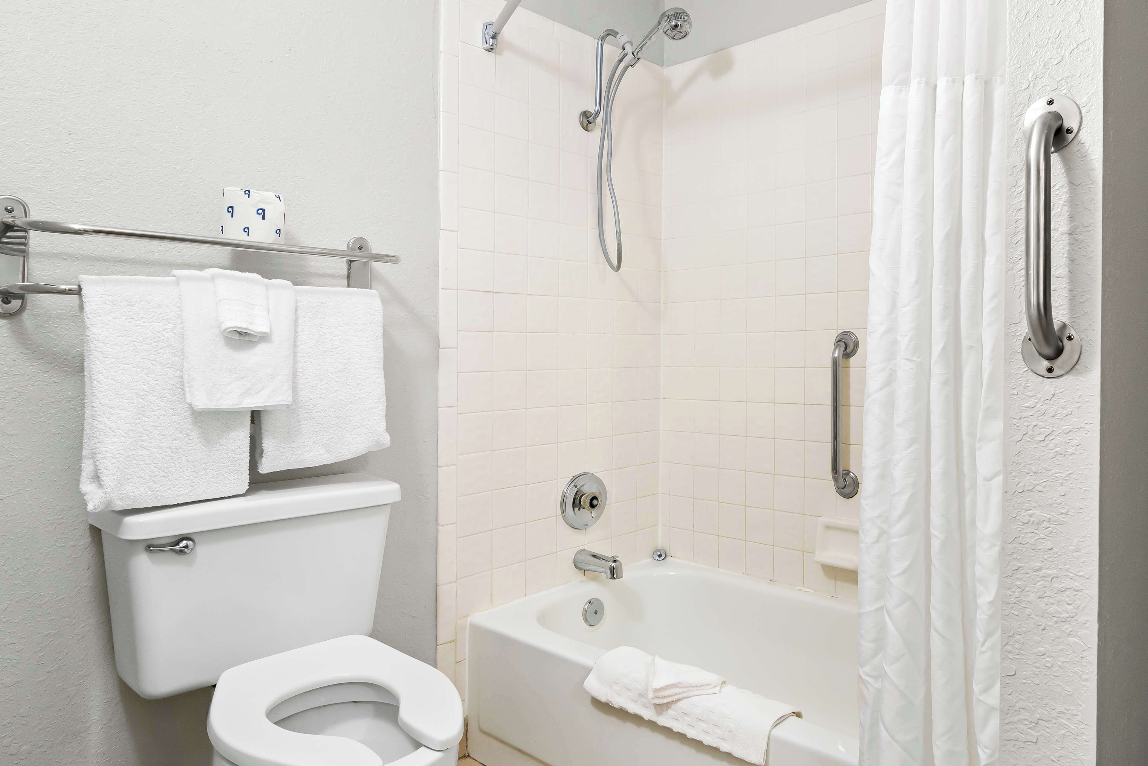 A bathroom with a toilet, a bathtub, and a shower.