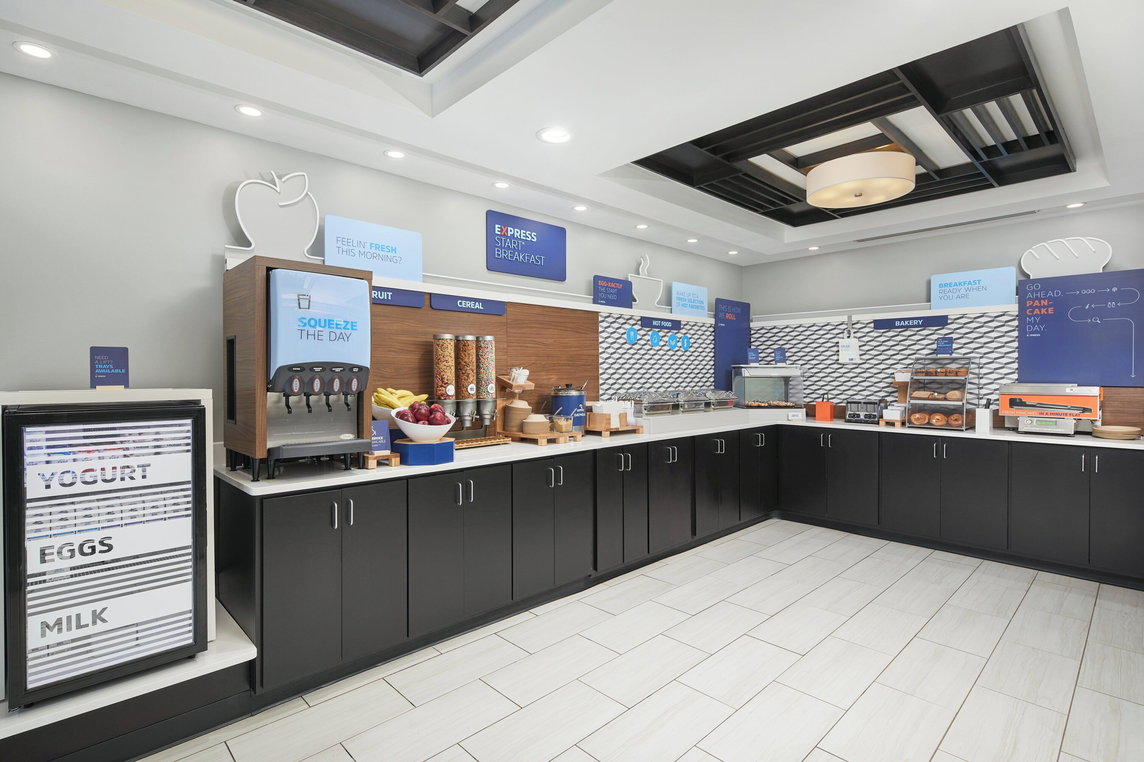 A modern breakfast area with a self-serve station, including options for yogurt, eggs, and milk.