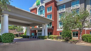 Ein Holiday Inn Express Hotel mit überdachter Eingangspartie, Backsteinfassade und großen Fenstern.