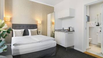 A hotel room with a bed, a bathroom, and a mirror.