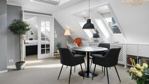 Quarto moderno estilo loft com claraboia, área de refeições com mesa redonda e estante embutida.