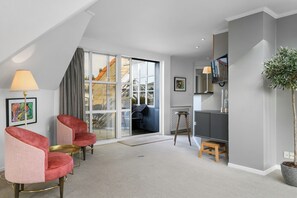 Grand Suite | Living area | 32-inch flat-screen TV with cable channels, books
