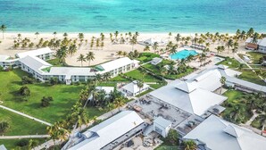 An aerial view of a resort with a beach, palm trees, and a swimming pool. - Viva Fortuna Beach by Wyndham, A Trademark Resort (Freeport)