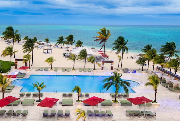 Zona de piscina en un resort con vista a la playa y al océano.